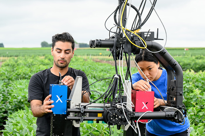 students working on drone in field