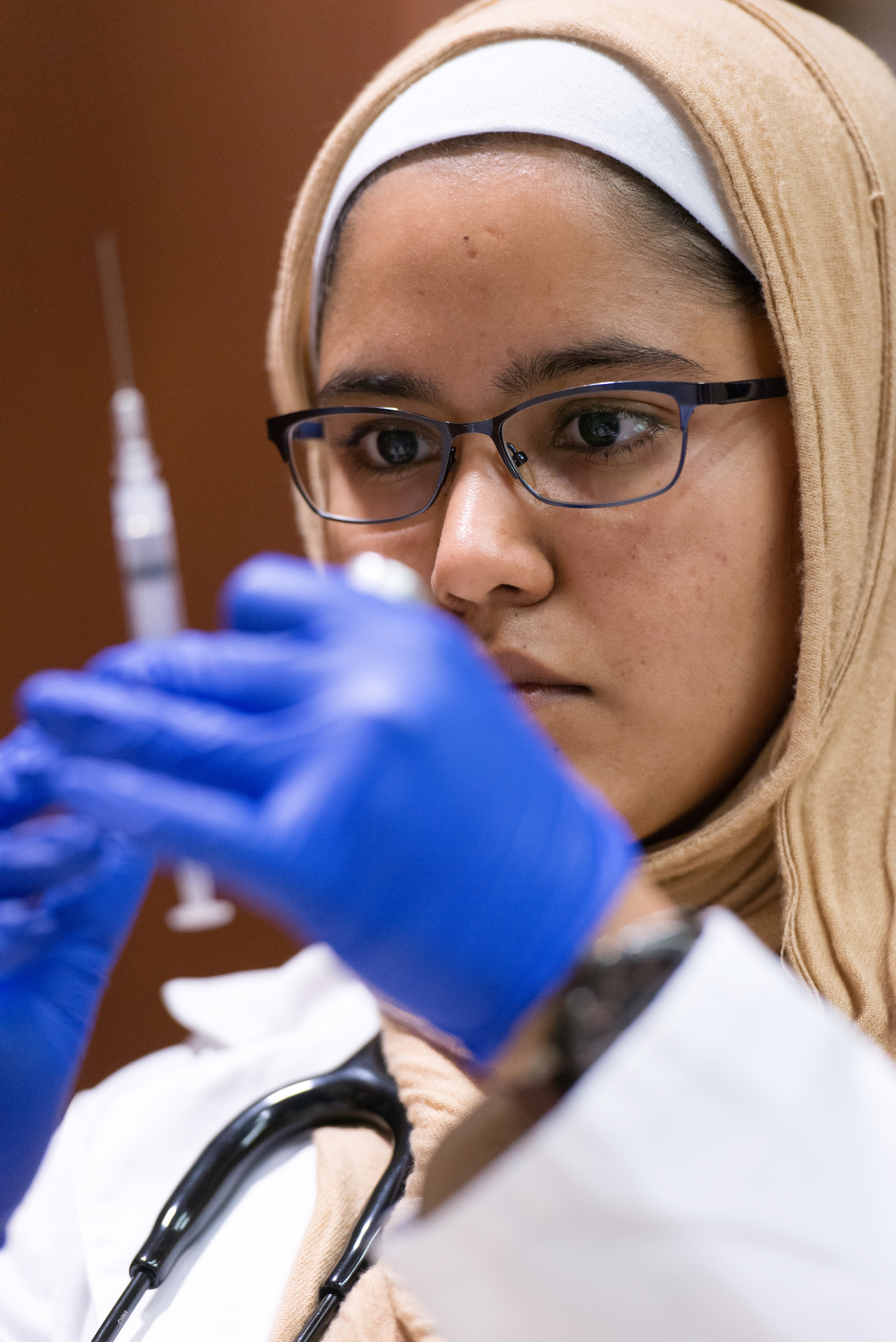 Medical worker holding a needle.