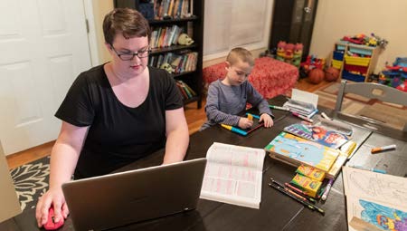 Mom at laptop at home with child