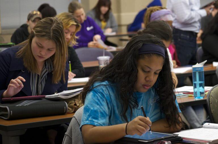 students in class doing work at desks