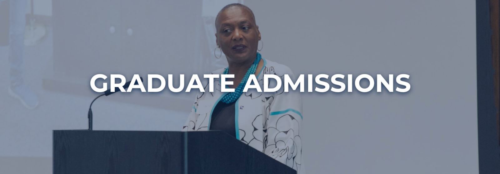 African American woman in nice jacket and necklace standing at podium