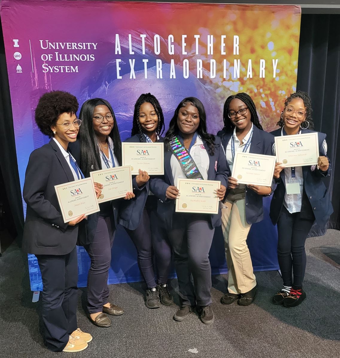 six Black female students holding SAA certificates