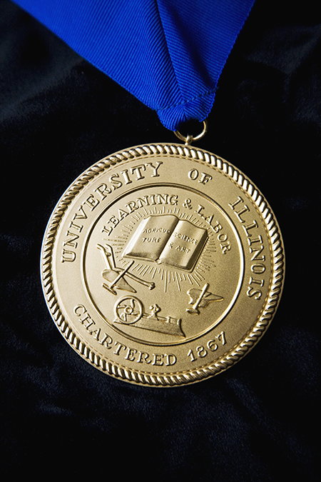 Gold medallion of U of I seal on blue ribbon