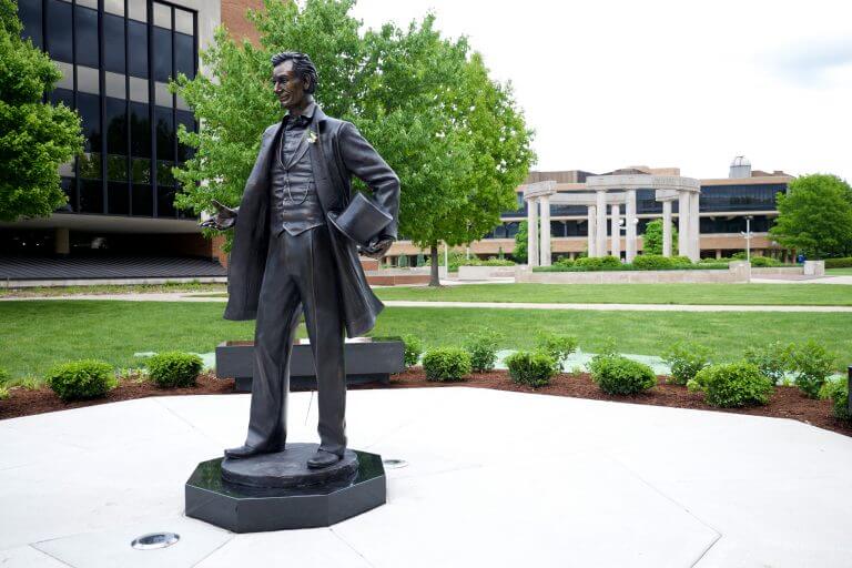27804280421_b154a748e9_o-768x512.jpg Abraham Lincoln statue on UIS campus in front of collonade