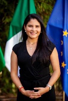A person standing in front of flagsDescription automatically generated